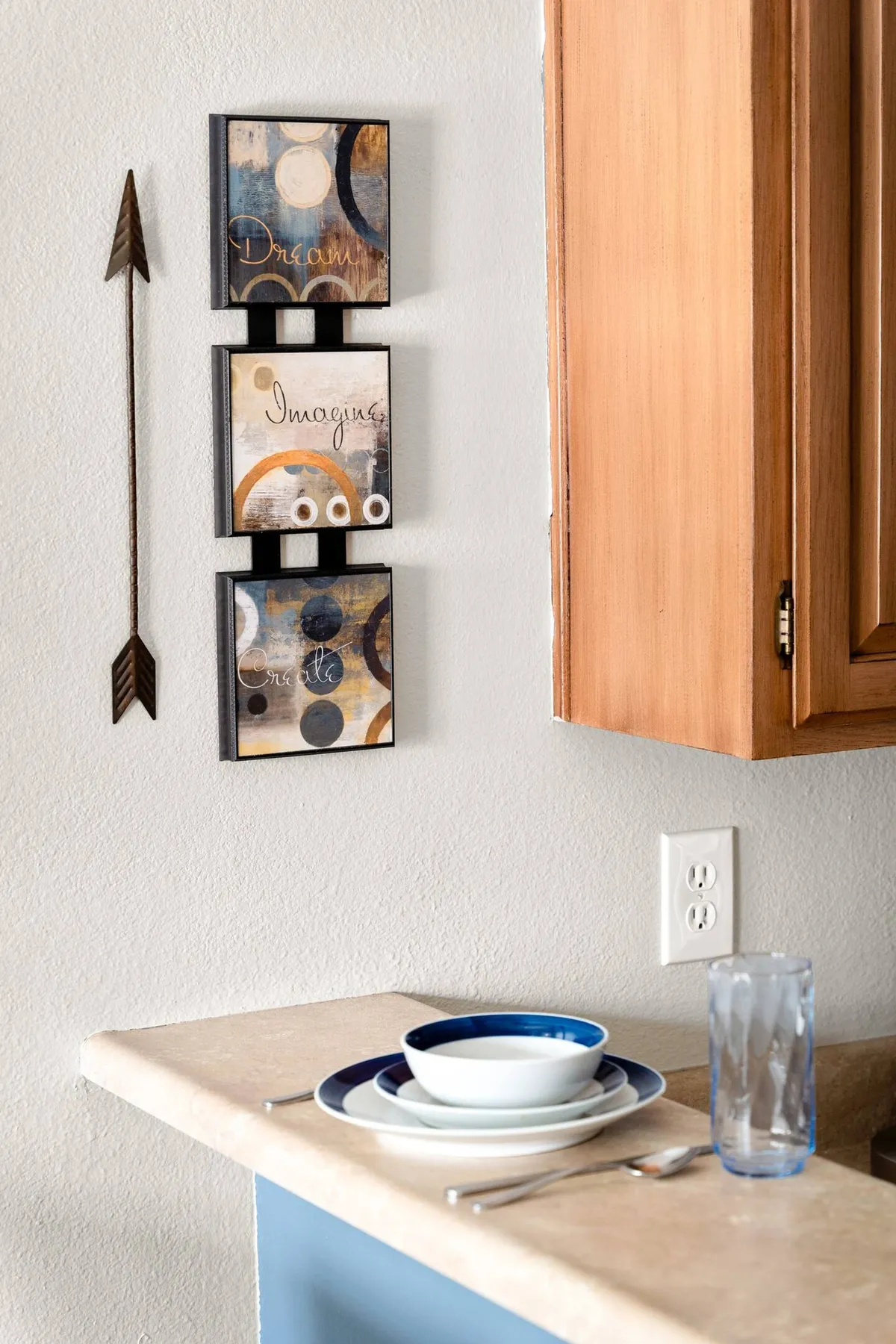 A stylish dining setup is front and center, featuring a wooden dining table, contemporary chairs, decorative wall art, and warm wooden cabinetry. The space feels intimate and inviting, ideal for both casual meals and entertaining guests.