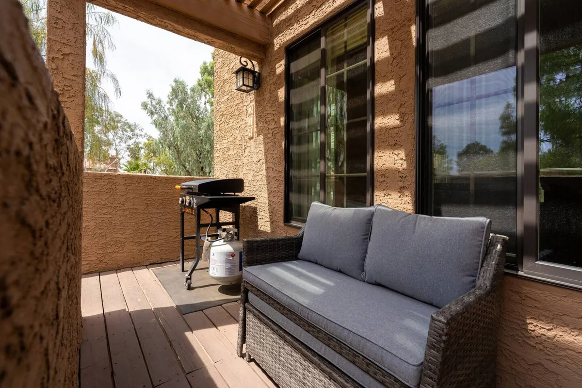 An inviting outdoor seating area with a grill, surrounded by windows that suggest a seamless indoor-outdoor lifestyle. The space is perfect for casual gatherings, entertaining friends after a day in the city, or relaxing at sunset.